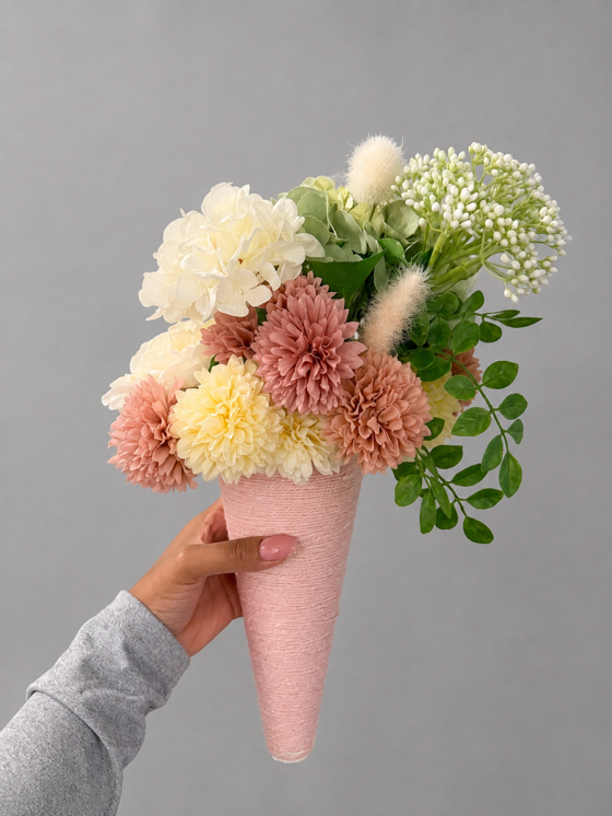 Custom bridal party bouquet in a long blush cone with ivory and dusty rose flowers and trailing greenery